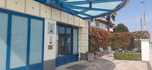 Busca科勒图酒店的人行道上设有蓝色门和椅子的建筑