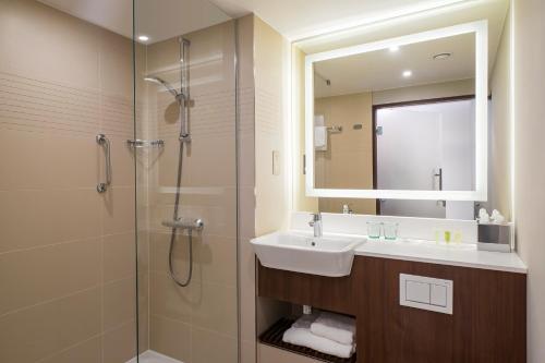 因弗内斯Courtyard by Marriott Inverness Airport的浴室配有盥洗盆和带镜子的淋浴