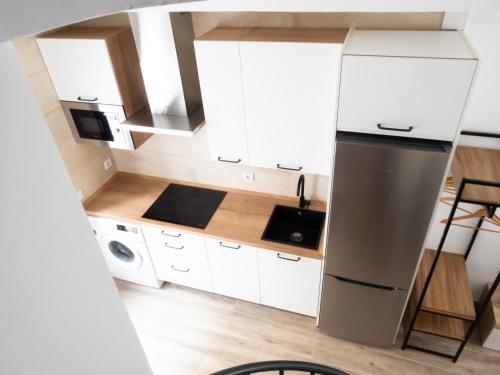 阿维拉VUT Adarve的厨房配有白色橱柜和冰箱。