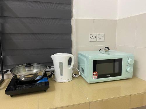 斯里曼绒Spacious+Minimal+Manjung City Centre的厨房柜台配有微波炉和烤面包机。