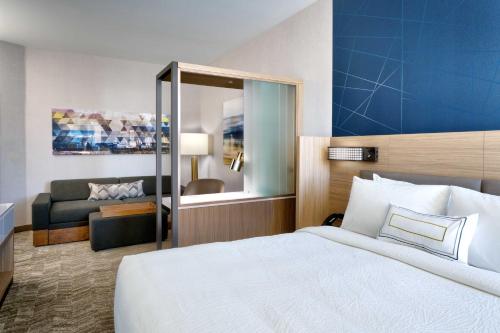 西瓦利城SpringHill Suites By Marriott Salt Lake City West Valley的酒店客房设有床和客厅。