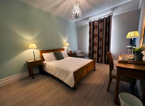 克利夫罗Station Lounge & Rooms的酒店客房配有一张床、一张书桌和一张书桌。