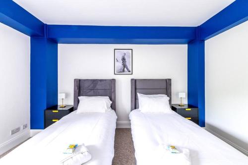 布里斯托Modern Skyfall with FREE PARKING for Families & Business by Prescott Apartments的蓝色墙壁客房的两张床