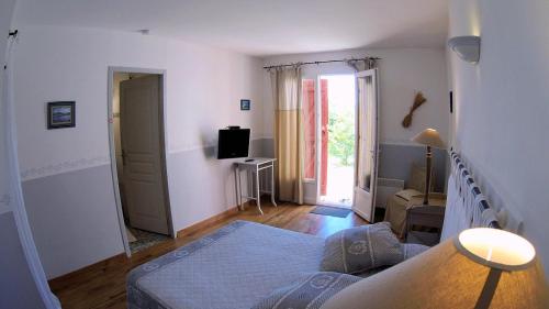 BaudinardLa Farigoule (Chambres d'Hôtes)的一间卧室配有一张床和一台电视