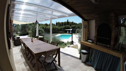 BaudinardLa Farigoule (Chambres d'Hôtes)的一个带桌子并享有游泳池景致的庭院