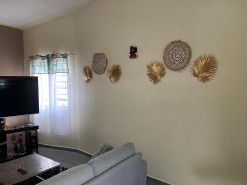 MamoudzouCentral Appart的客厅配有沙发,墙上挂着一些帽子