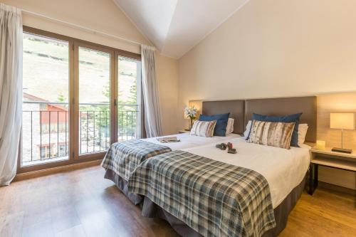 博尔德斯·代瓦里拉皮埃尔&法坎斯安道尔博尔德恩法力拉酒店的一间卧室设有一张大床和一个大窗户