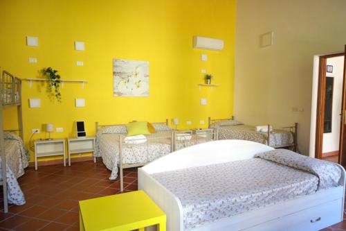 庞贝B&B Pompei Hostel Deluxe的一间卧室设有一张床和黄色的墙壁