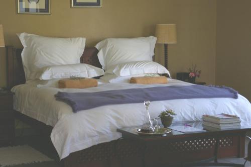 雾观Plumbago Guest House的一张配有白色床单和枕头的大床