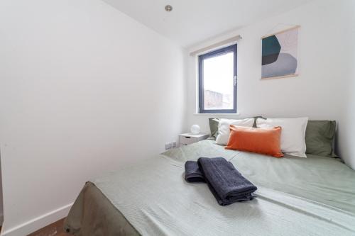 伦敦Arte Stays - 3-Bed 3-Bath Nordic Style Minimalistic Flat, Hackney Downs station 2 min walk, Great Location, Parking, Weekly or Monthly stays, Serviced Accommodation - 6 people的一间卧室配有一张床,上面有两条毛巾