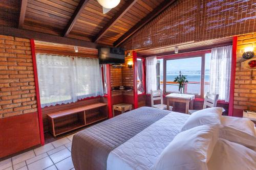 弗洛里亚诺波利斯Pousada Mar de Dentro的一间卧室配有一张床,享有海景