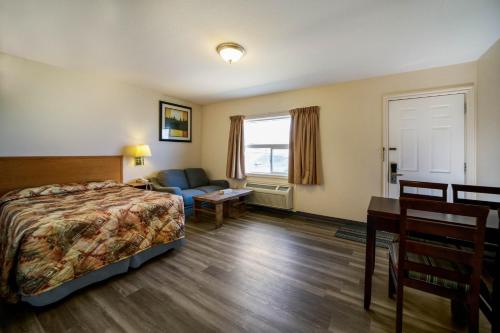 圣约翰堡Canadas Best Value Inn Fort St John的配有一张床和一张书桌的酒店客房
