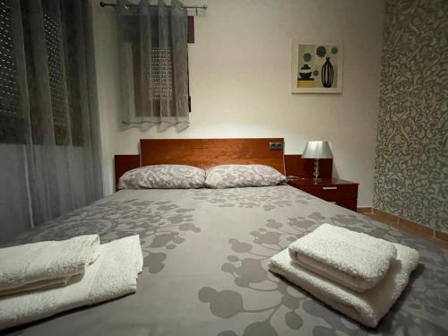 阿亚蒙特Costa Esuri, Ayamonte的一间卧室配有一张大床和毛巾