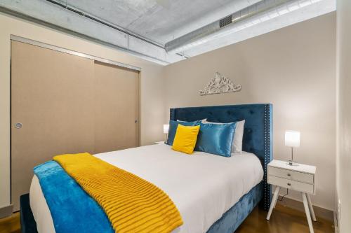明尼阿波利斯Sable 604的一间卧室配有蓝色和黄色枕头的床