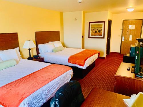 HoisingtonPARK VIEW INN & SUITES的酒店客房设有两张床和一张桌子。