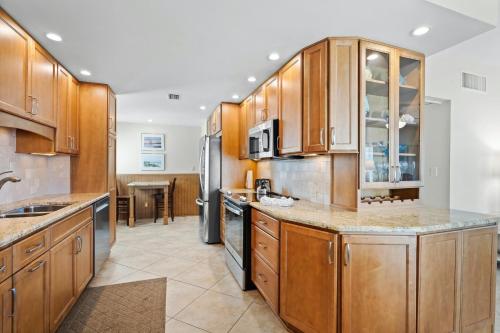 Point O'RocksIsland House Beach Resort 13S的一个带木制橱柜和不锈钢用具的大厨房