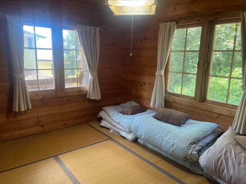 志摩市Log house Hata - Vacation STAY 29001v的小木屋内一间卧室,配有两张床