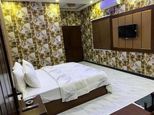 卡拉奇Defence Orchard DHA Karachi的一间卧室配有一张床,墙上配有电视
