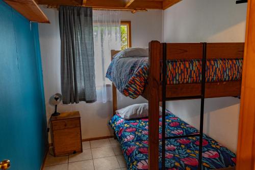 帕普多Cabañas Hostel Aquario Papudo的一间卧室设有两张双层床和一扇窗户。