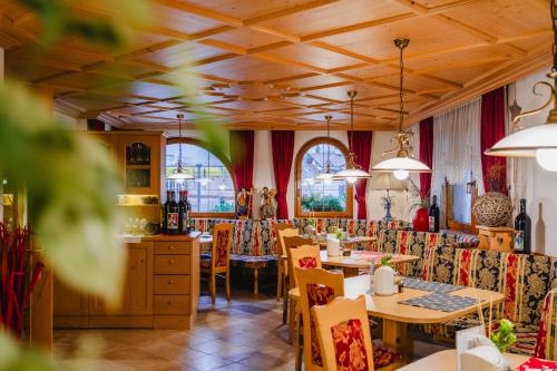 圣克里斯蒂娜Garni Hotel Belalp的餐厅设有桌椅和窗户。