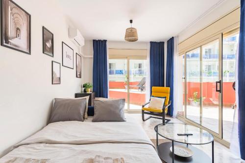 罗列特海岸Grand Apartament Lloret的一间卧室配有一张床和一张玻璃桌