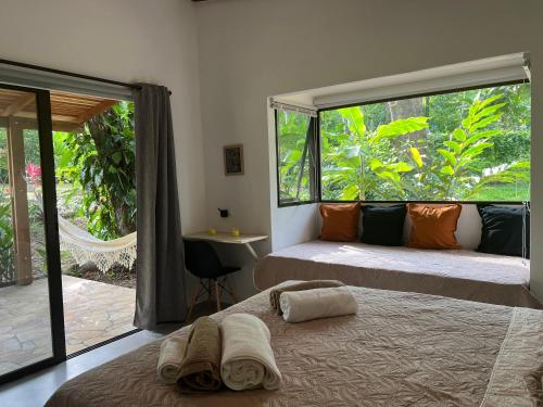 CabuyaFeeling Trees Jungle Lodge的一间卧室设有两张床和大窗户