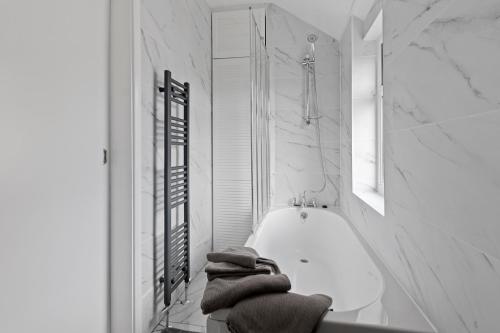 SkegbyModern 3-Bed Terraced House in Sutton-In-Ashfield的白色的浴室设有浴缸和毛巾。