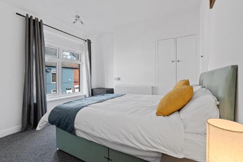 SkegbyModern 3-Bed Terraced House in Sutton-In-Ashfield的一间卧室配有一张带黄色枕头的大床