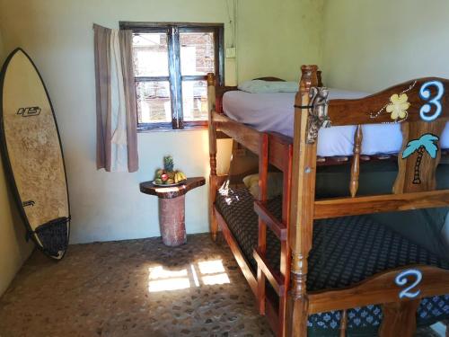 托拉Monkey House Hostel的一间卧室设有两张双层床和冲浪板