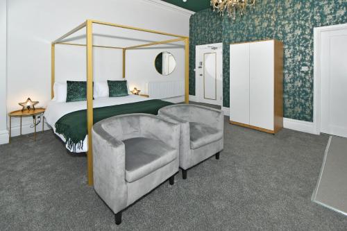 特伦特河畔斯托克One Battison - Affordable Rooms, Suites & Studios in Stoke on Trent的一间卧室配有一张天蓬床和一把椅子