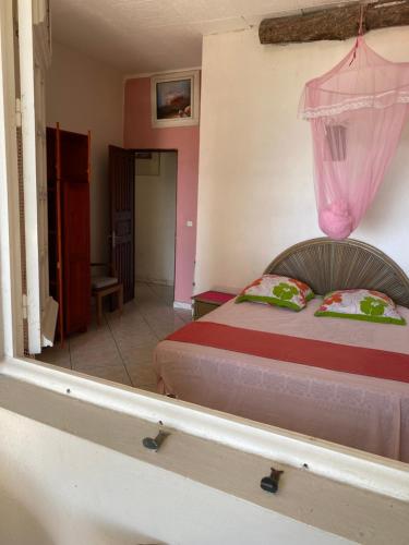 法兰西堡La Porte Du Paradis的一间卧室配有一张床铺,上面有粉红色窗帘