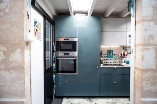 波尔多Pretty house - near botanical garden的厨房配有蓝色橱柜和炉灶。