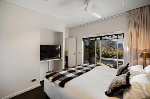 弗兰克顿Queenstown Hot Tub Apartment的一间卧室设有一张大床和一个大窗户