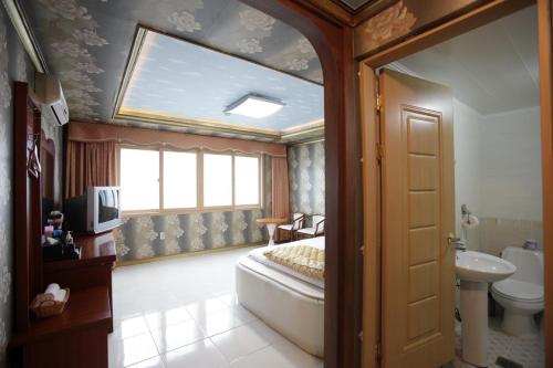 巨济Pataya Motel的一间卧室配有床、水槽和窗户