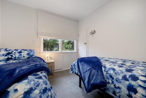 陶朗加Restful Retreat的一间卧室设有两张床和窗户。