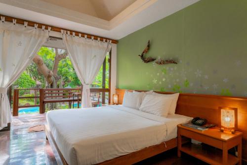 华欣班東考度假村 的一间带大床的卧室和一个阳台