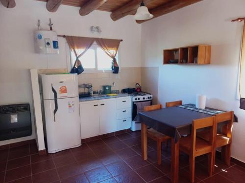 卡皮亚德尔德尔蒙特Cabaña La Yumba的厨房配有桌子和白色冰箱。