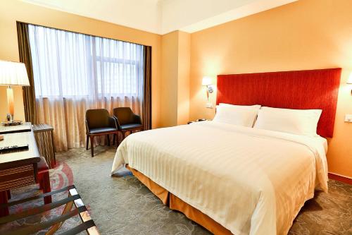 深圳深圳丽都酒店(罗湖)的一间设有大床和窗户的酒店客房