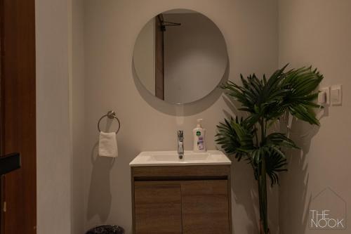利雅德luxury 3BD Condo Near the Boulevard的浴室设有水槽、镜子和植物