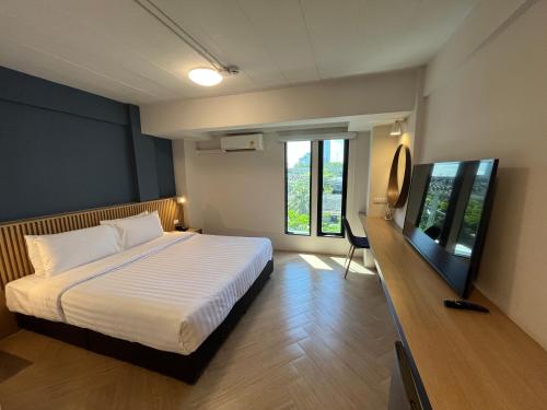 曼谷De Botan Bangna的一间卧室配有一张床和一台平面电视