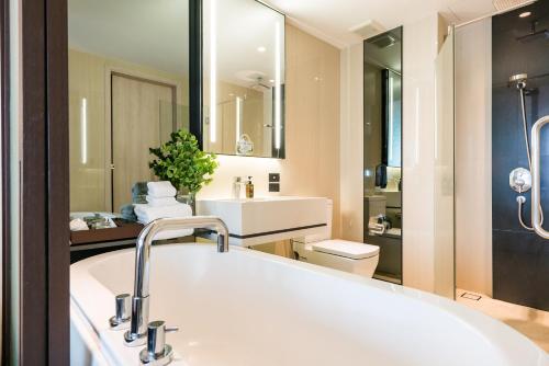北芭堤雅The Siamese Hotel by PCL的浴室配有大型白色浴缸和水槽