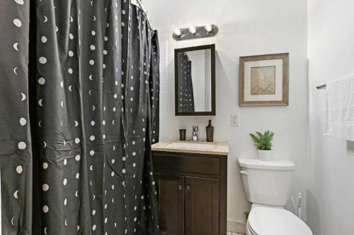 芝加哥Charming 3BR Chicago Apt in Prime Location的浴室设有黑色淋浴帘和卫生间。