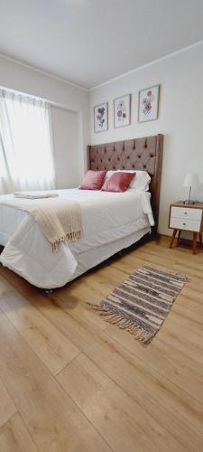 利马Moderno departamento de 03 habitaciones的一间卧室设有一张大床,铺有木地板