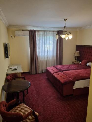 TecuciMatrix Hotel的酒店客房配有红色的床和一张桌子