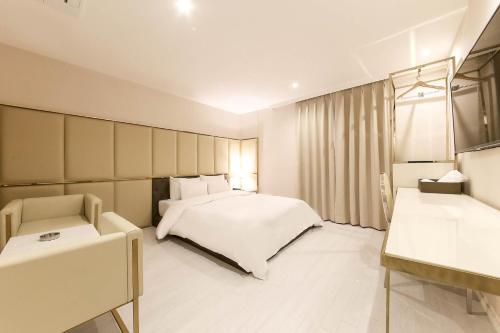 首尔Hotel Star Premier Yeoksam的卧室配有白色的床、椅子和窗户
