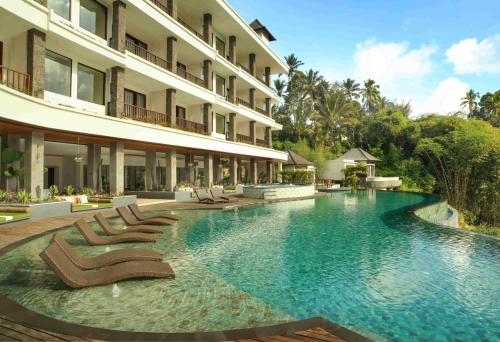 德格拉朗Cicada Luxury Resort - Ubud的一个带躺椅的游泳池和一间酒店