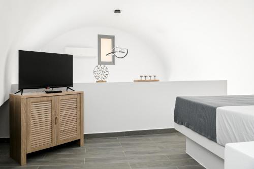 莫诺利索斯Villa Eleana的一间卧室配有一张床和一台平面电视