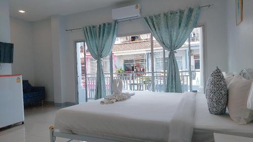 芭东海滩Cinderella Residence的一间卧室设有一张大床和大窗户