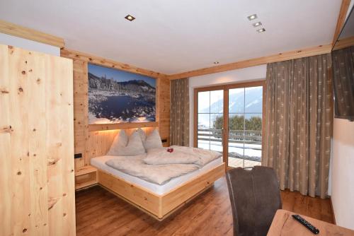 克里姆尔Krölls Alpenchalet的一间卧室设有一张床和一个大窗户