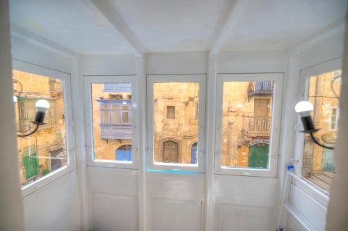 瓦莱塔Charming house in the heart of Valletta CPAC1-3的客房设有3扇窗户,享有大楼的景致。